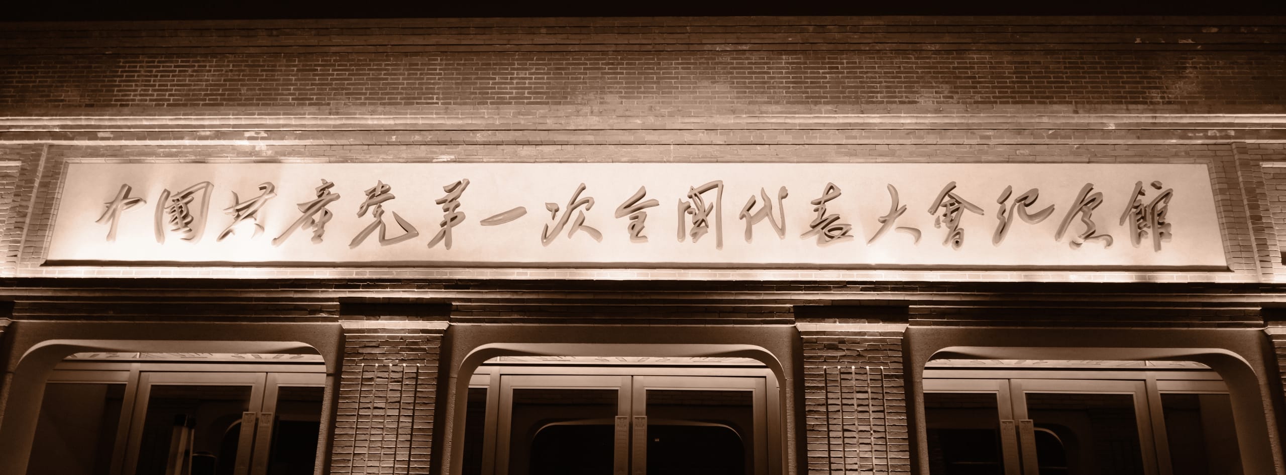 旧式木门上方悬挂一块横向书法匾额。