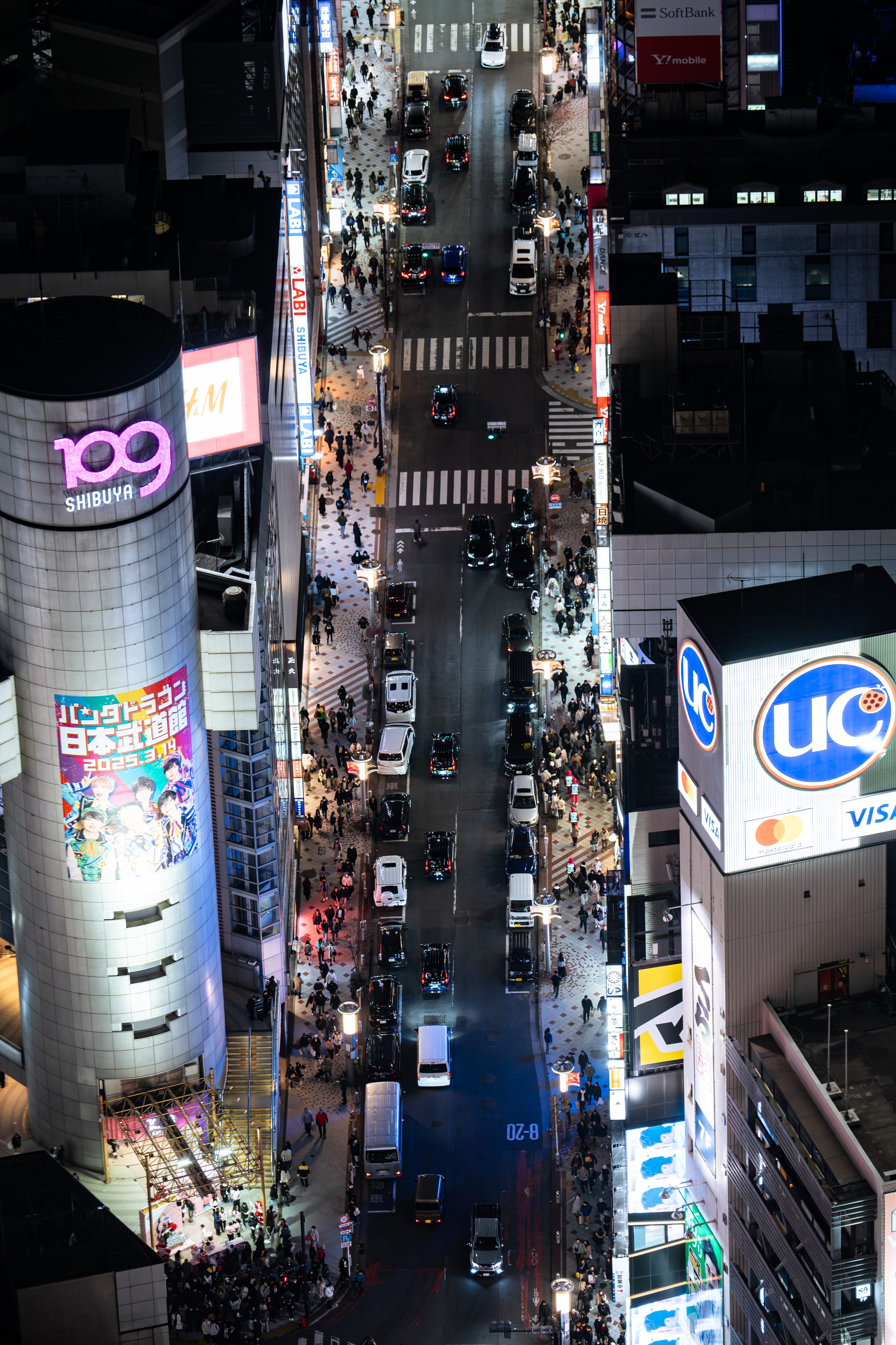 从高处俯瞰霓虹灯密集的夜间商业街区。