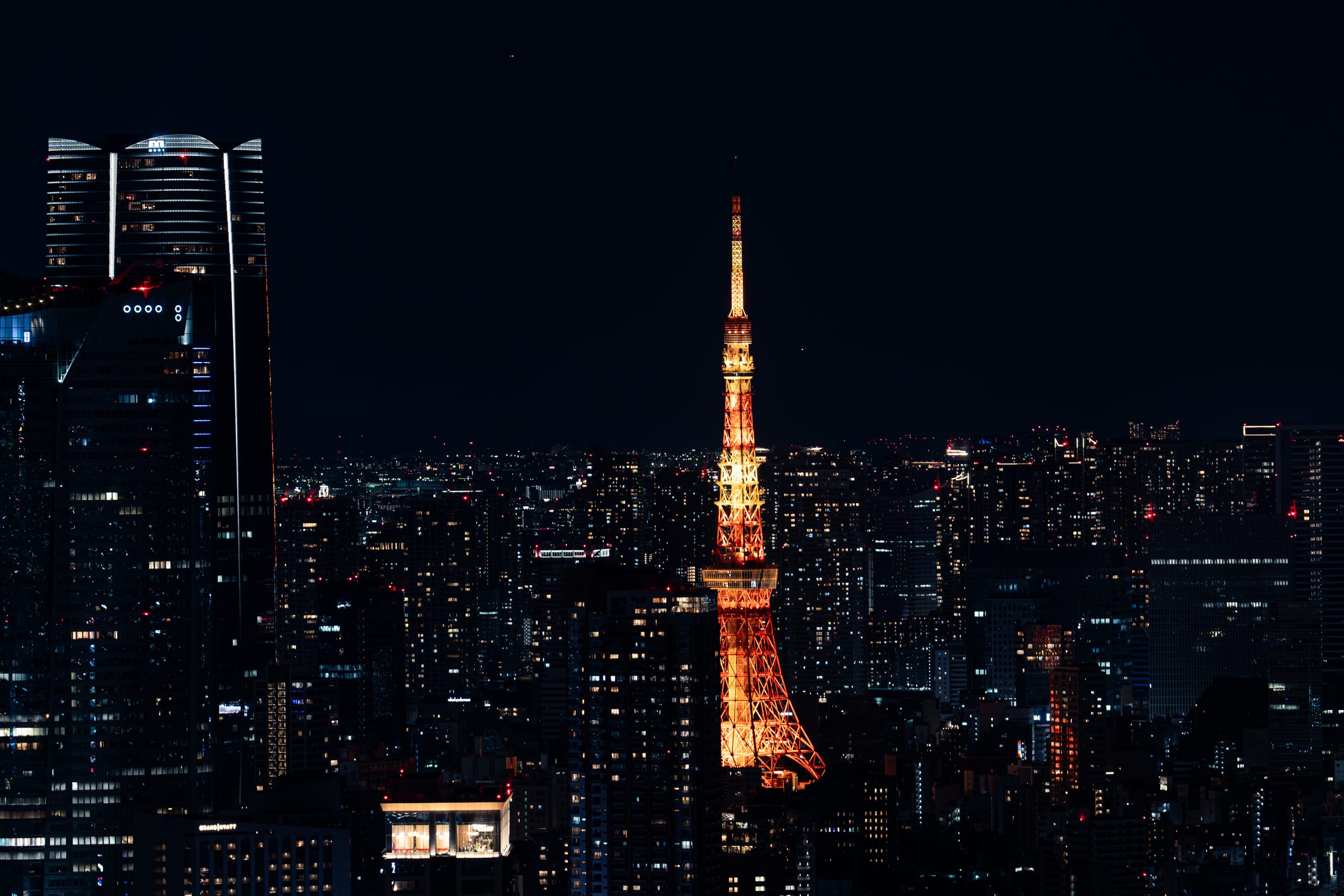 橙红色高塔在深色城市夜景中央发光。