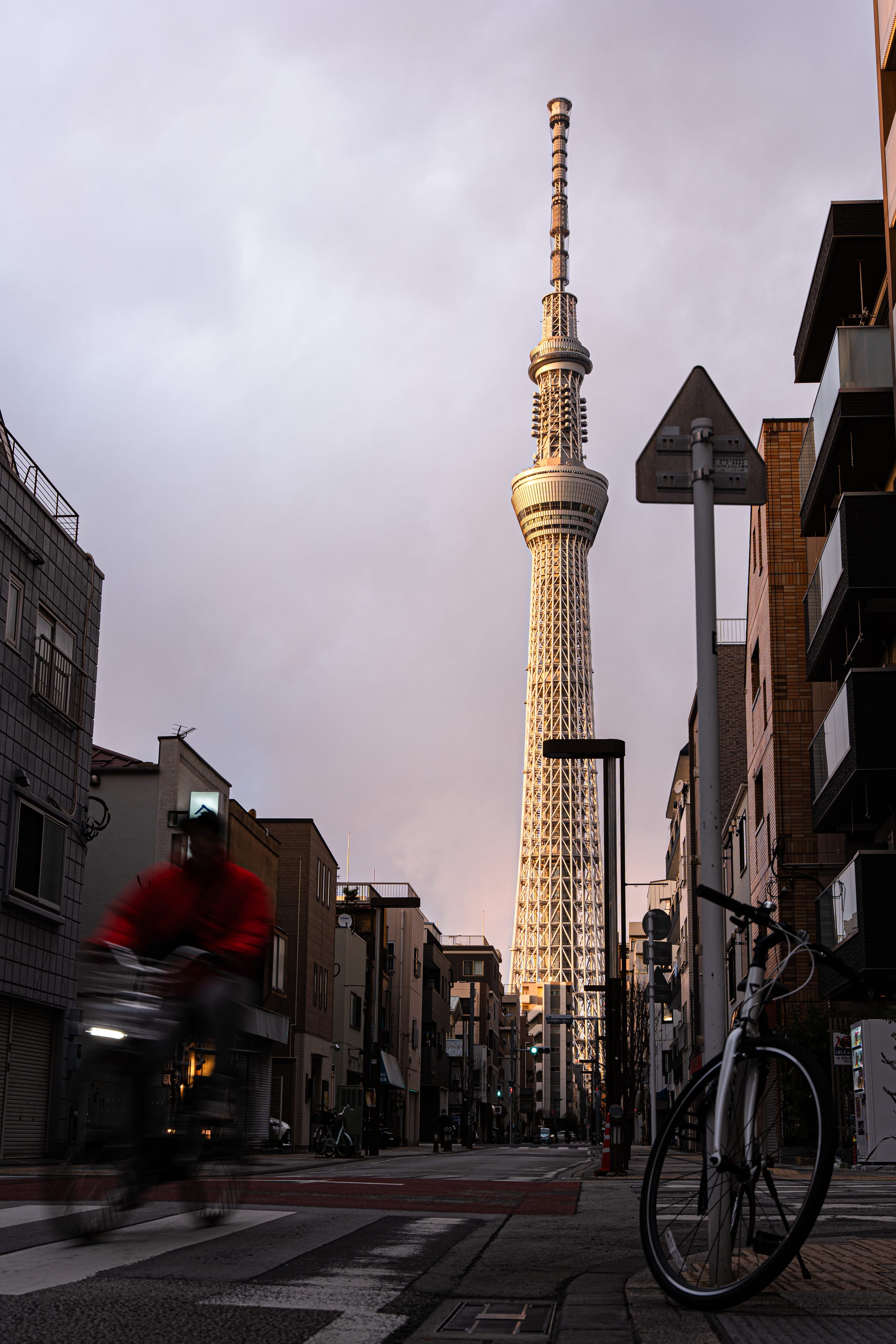 街道尽头竖立一座高塔，前景停着自行车。