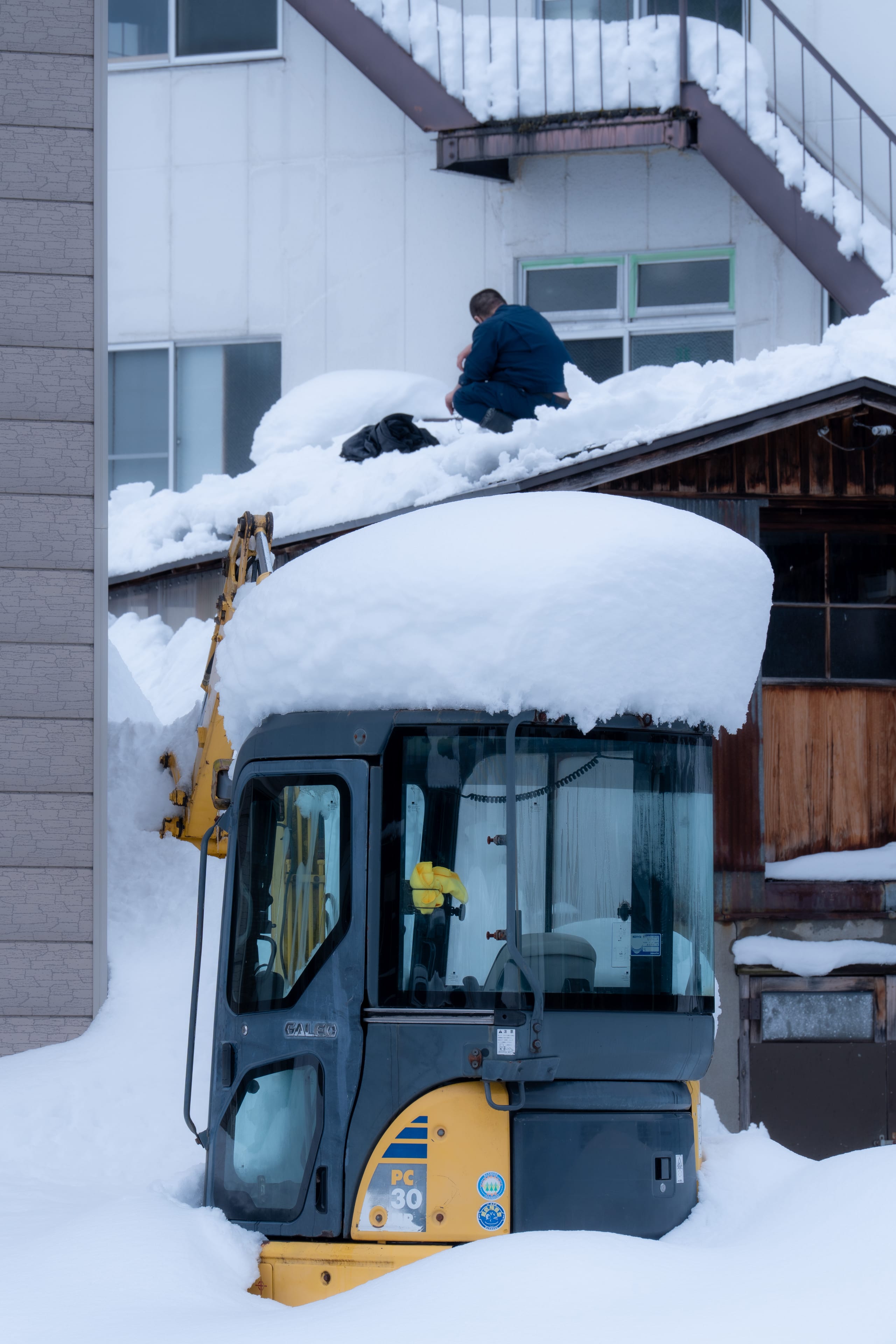 一辆工程车辆几乎被街边厚雪包围。