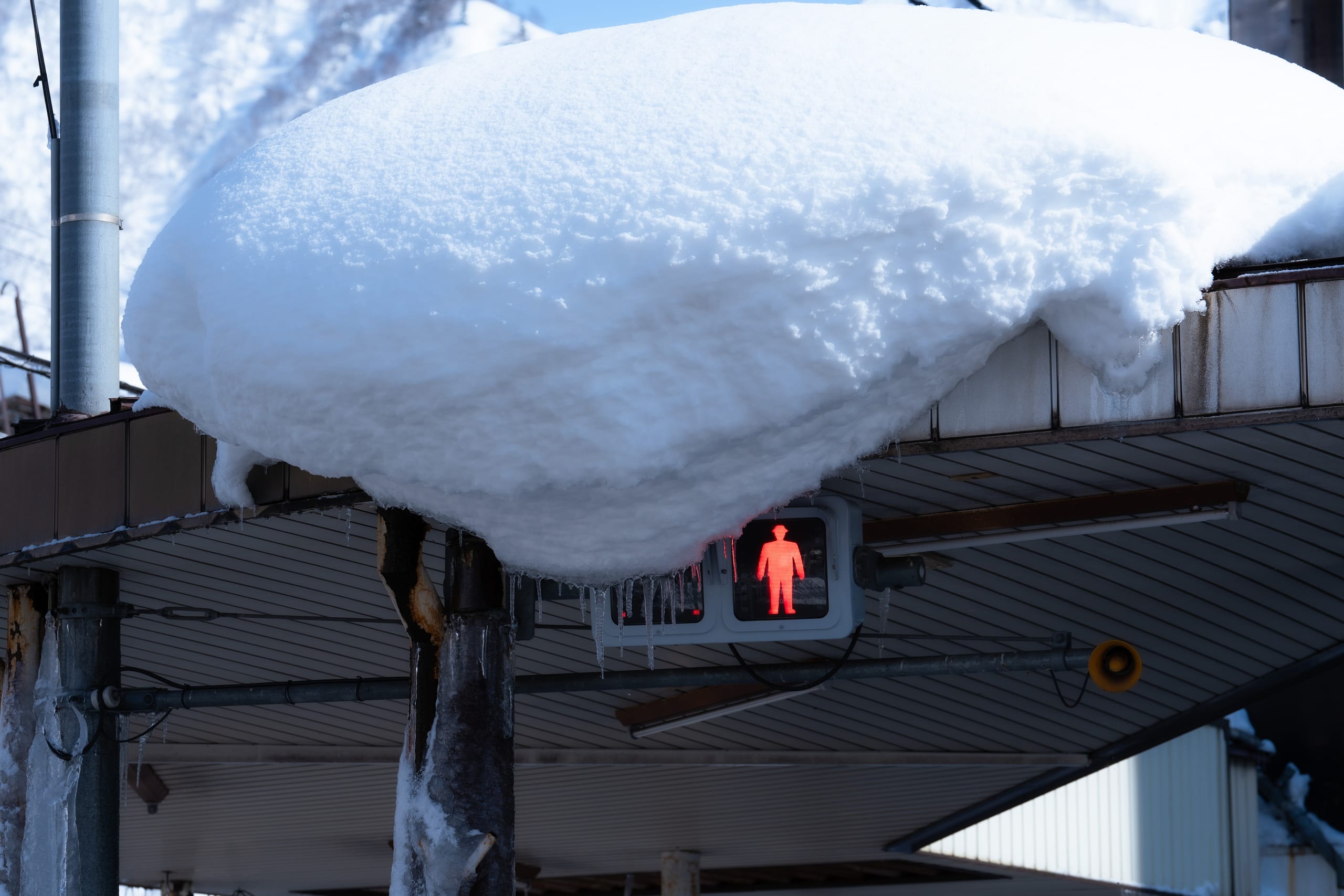 厚重积雪覆盖街头信号灯和附近屋檐。