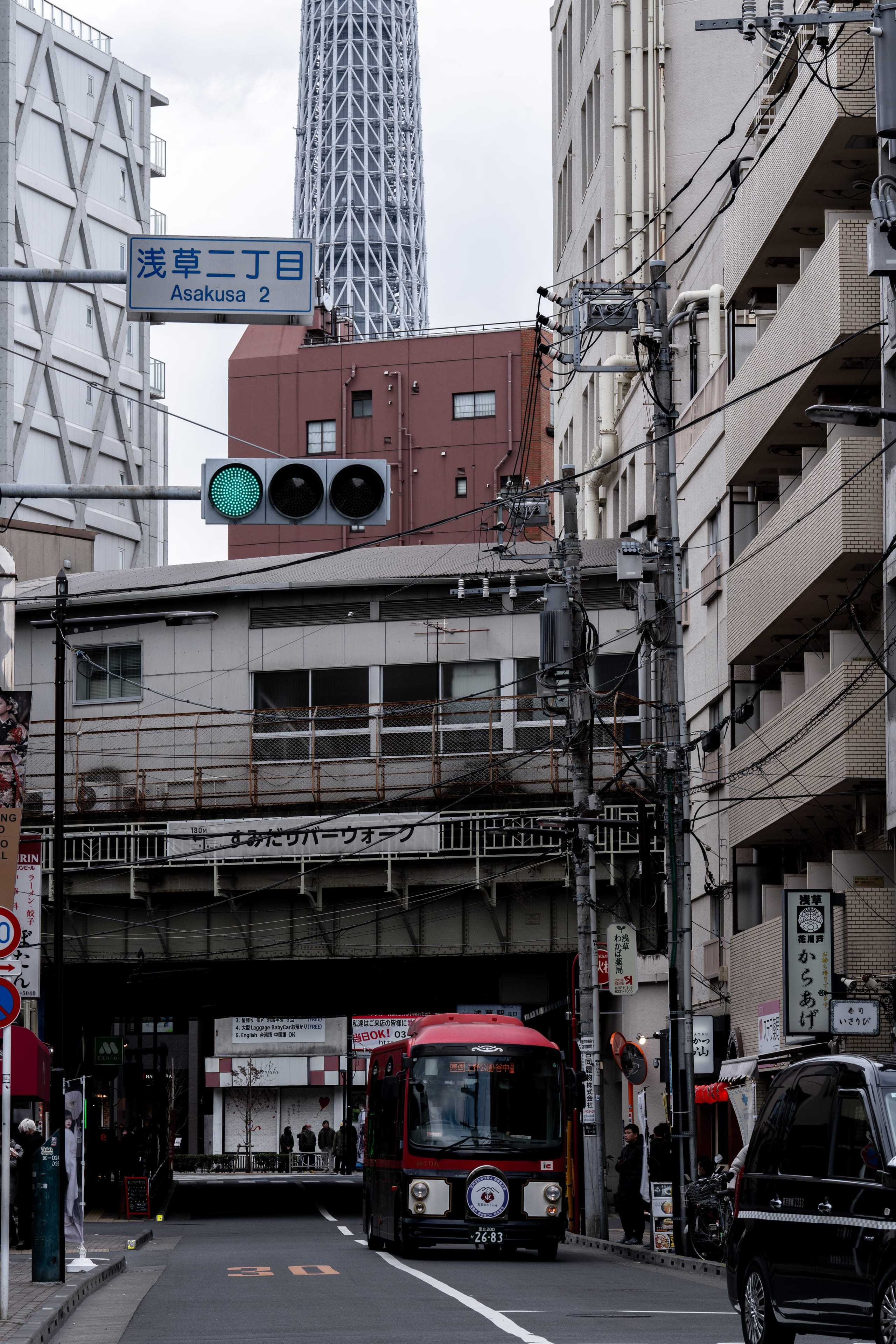 一列小型红色列车驶入狭窄城市街道。
