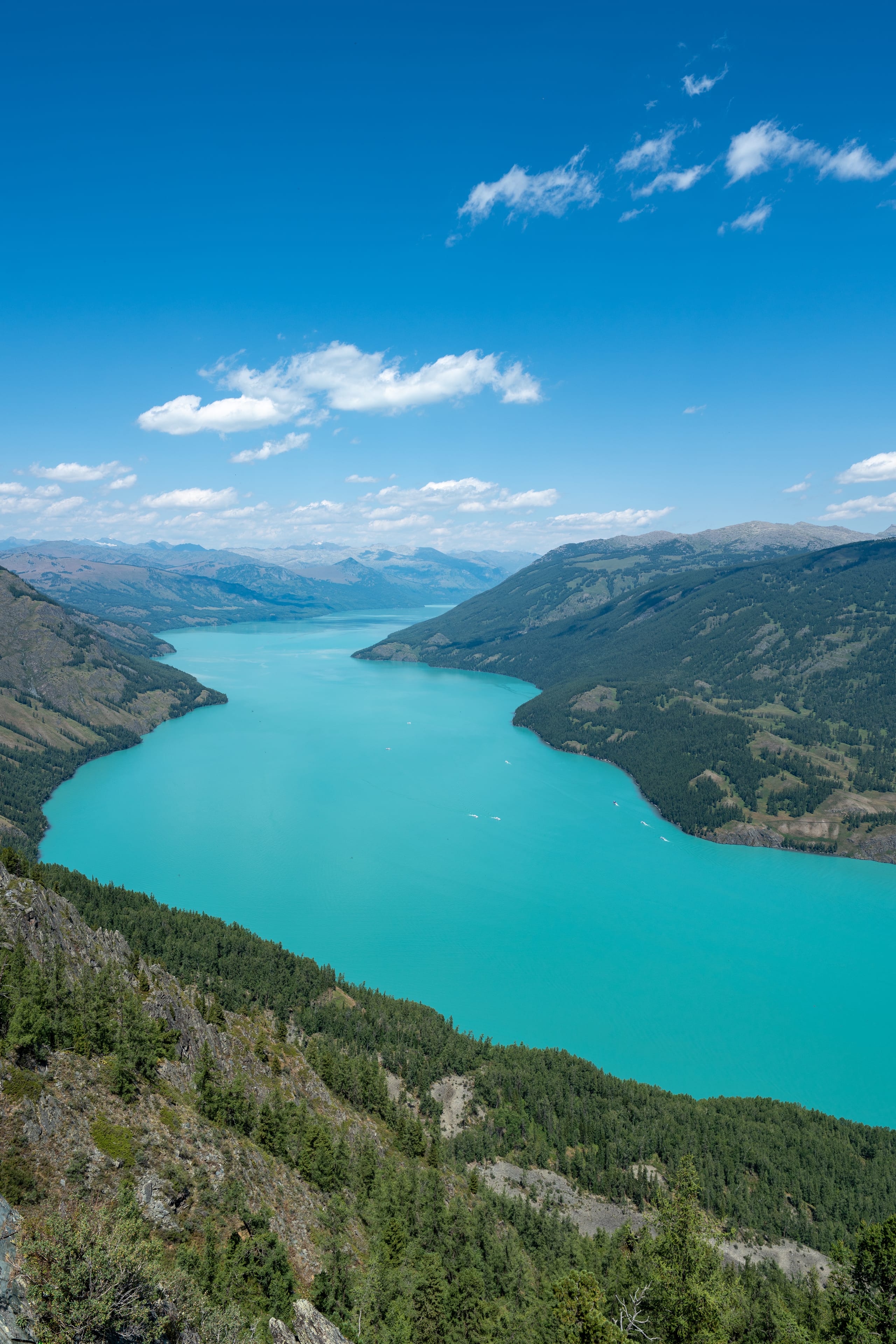 纵向俯瞰喀纳斯湖狭长水面，宝石绿色湖水延伸至远处山谷。