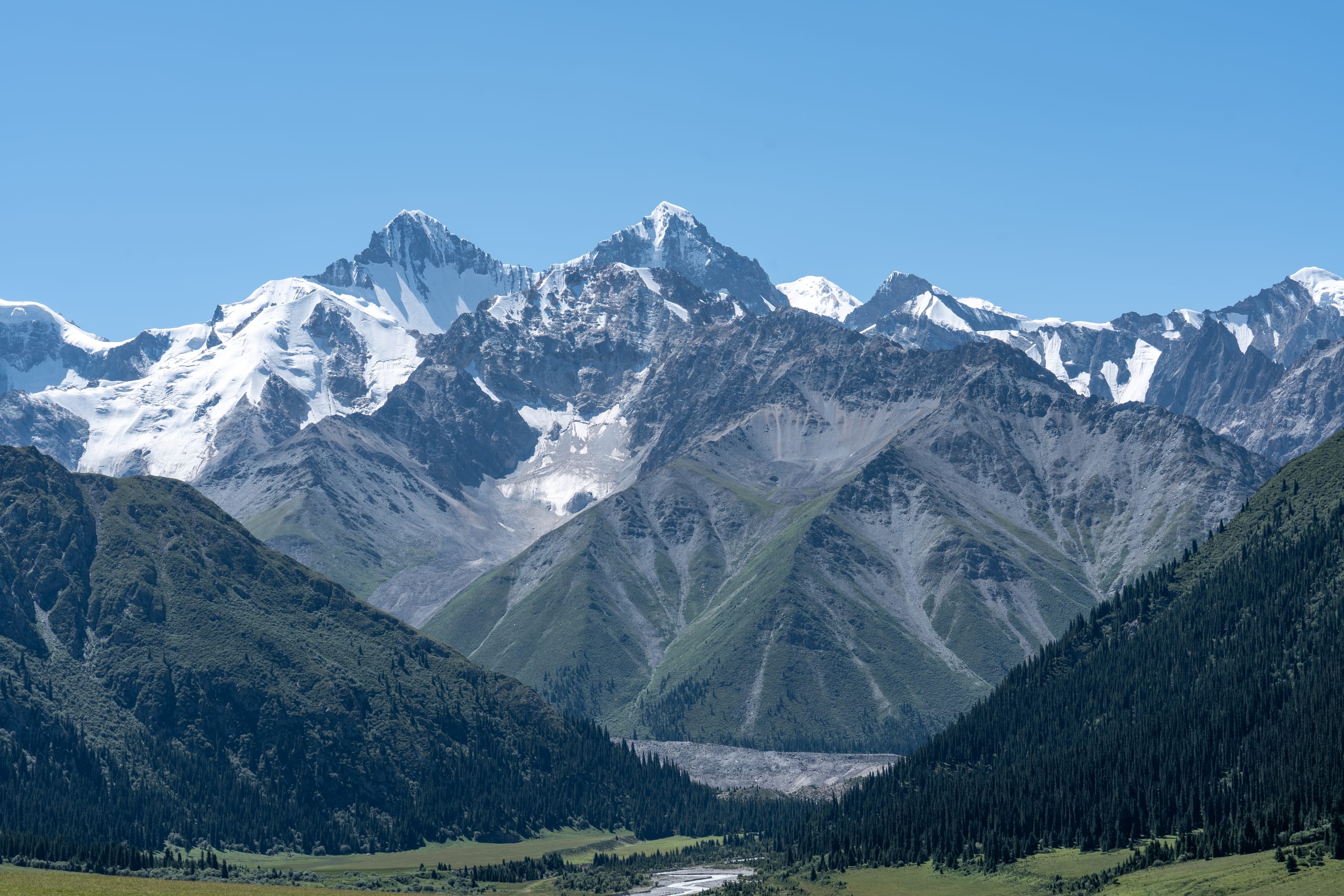 夏塔雪山主峰与木扎尔特冰川位于山谷尽头，雪线沿嶙峋山脊展开。
