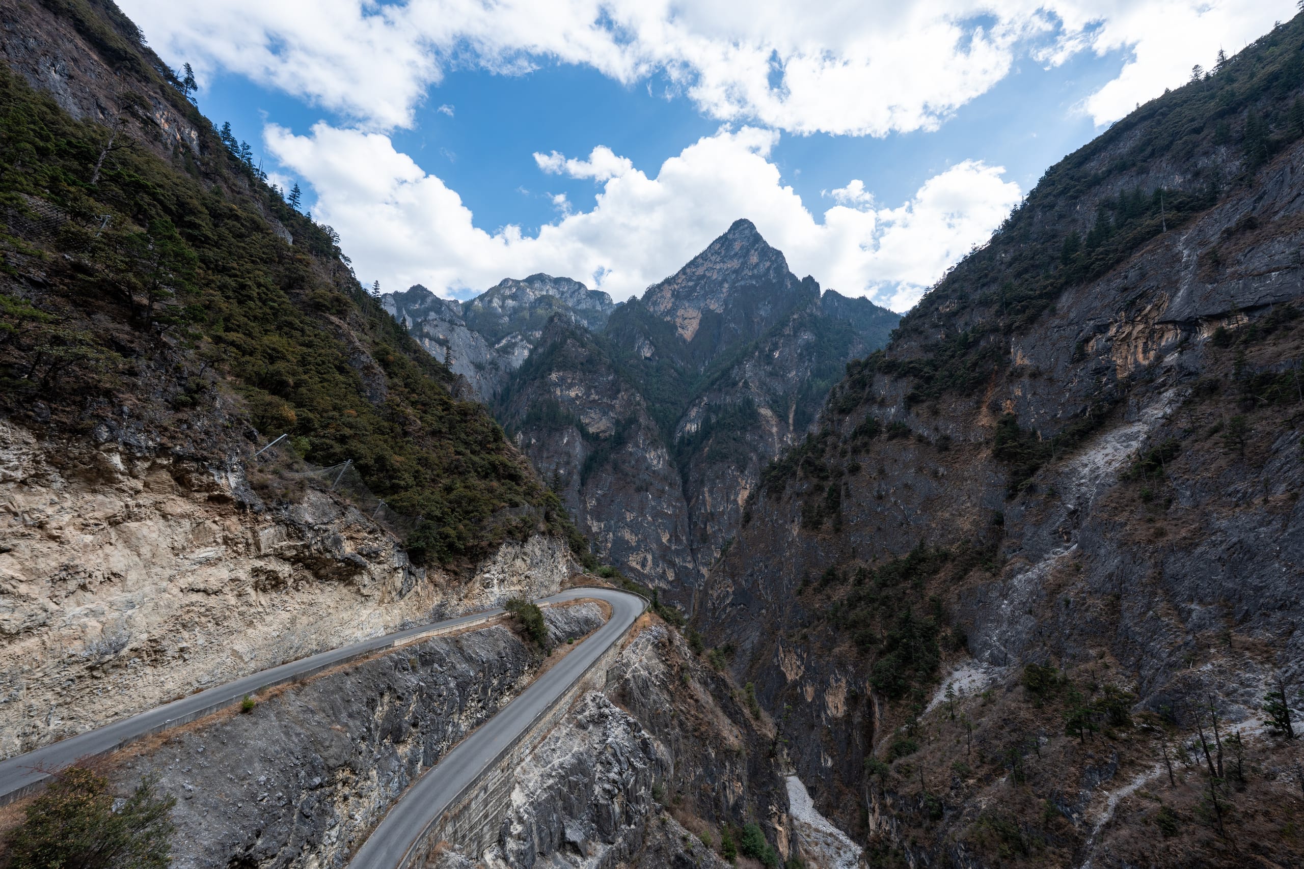 香格里拉大峡谷半山腰的盘山公路沿陡峭岩坡连续转弯。
